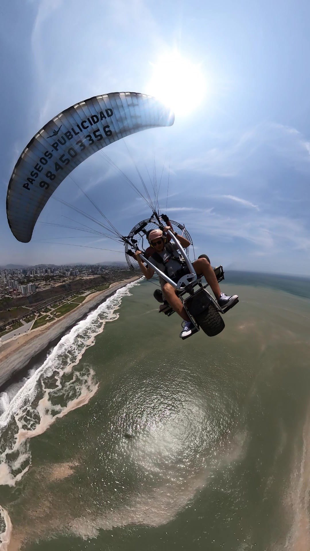 Experiencia de paratrike biplaza sobre la Costa Verde de Lima con vista panorámica de ciudad, mar y acantilados