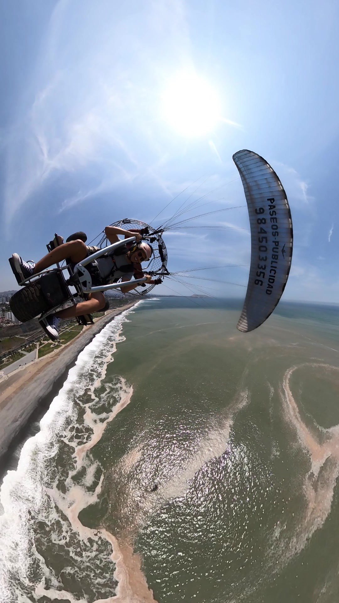 Vuelo extremo en paratrike sobre el océano Pacífico en Lima, Perú, con piloto certificado y clima soleado